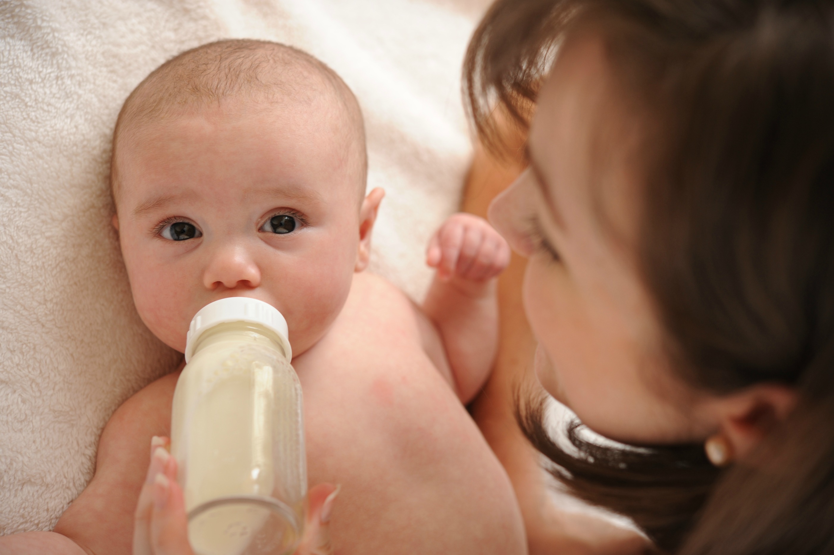 Нужно давать воду новорожденному при грудном. Молоко для детей. Вскормить молоком. Вода для новорожденных при грудном вскармливании. Женщина кормит ребенка из бутылочки.